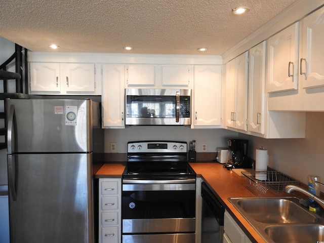 kitchen featuring sink, white cabinetry, appliances with stainless steel finishes, and a textured ceiling