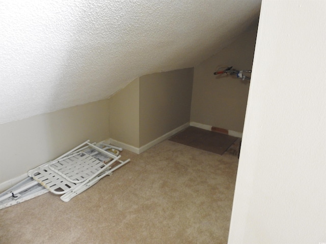 bonus room featuring vaulted ceiling, light colored carpet, and a textured ceiling