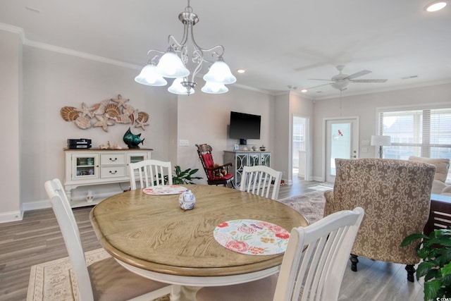 dining room featuring crown molding, ceiling fan with notable chandelier, and wood-type flooring