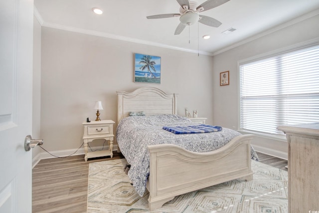 bedroom featuring ceiling fan, light hardwood / wood-style flooring, ornamental molding, and multiple windows