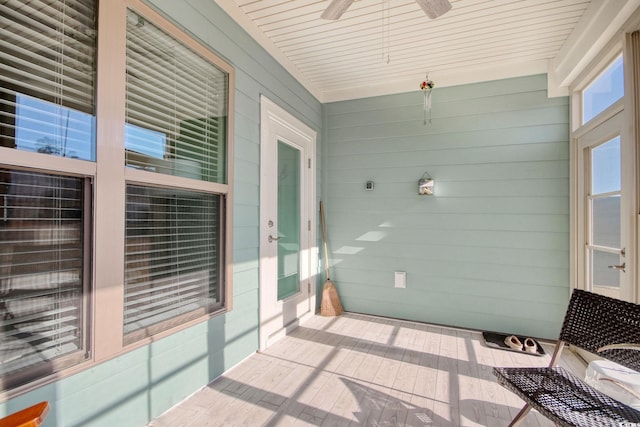 unfurnished sunroom featuring ceiling fan