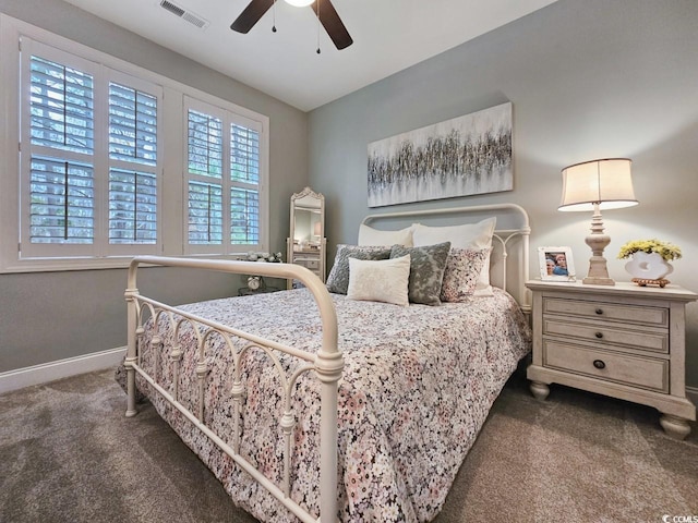 carpeted bedroom featuring multiple windows and ceiling fan