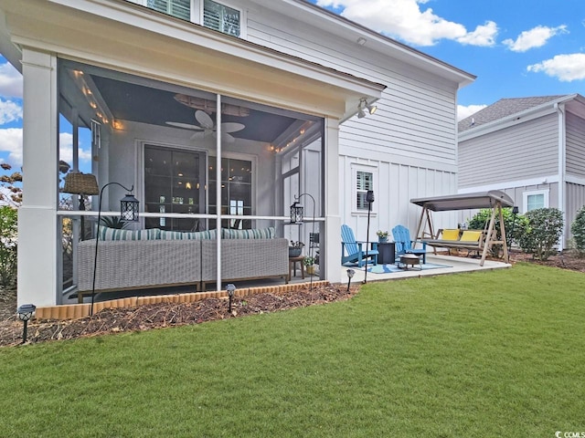 rear view of house with a yard, ceiling fan, an outdoor living space, and a patio