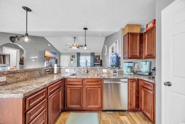 kitchen with sink, a textured ceiling, lofted ceiling, and dishwasher