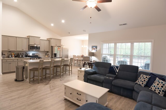 living room featuring high vaulted ceiling, ceiling fan, and light hardwood / wood-style flooring