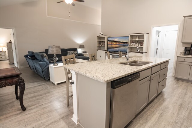 kitchen featuring sink, a kitchen island with sink, dishwasher, and gray cabinets