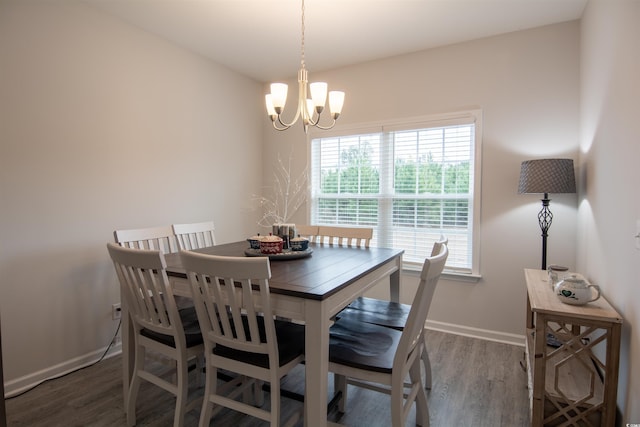 dining space with hardwood / wood-style floors and a notable chandelier