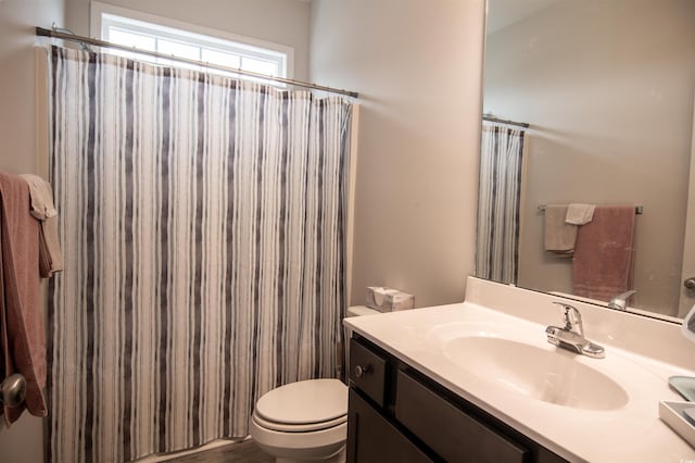 bathroom with a shower with curtain, vanity, and toilet