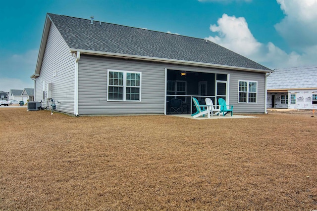 rear view of house featuring a lawn, a patio area, and central air condition unit