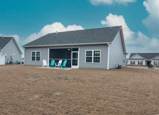 rear view of house featuring a lawn and a patio