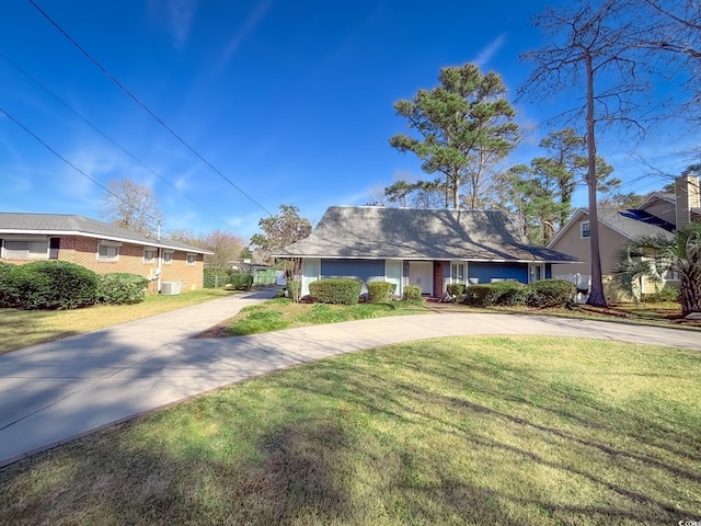ranch-style house with concrete driveway and a front lawn