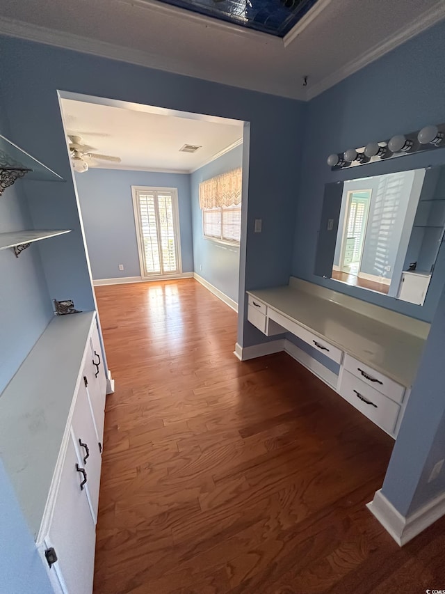hall featuring crown molding, baseboards, visible vents, and wood finished floors