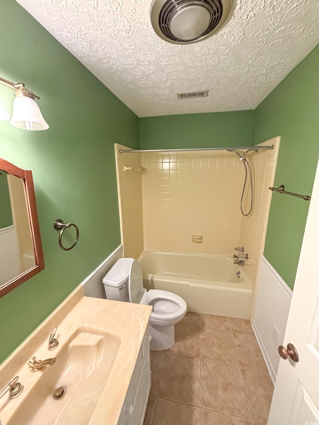 full bathroom with vanity, toilet, a textured ceiling, tile patterned floors, and shower / bath combination