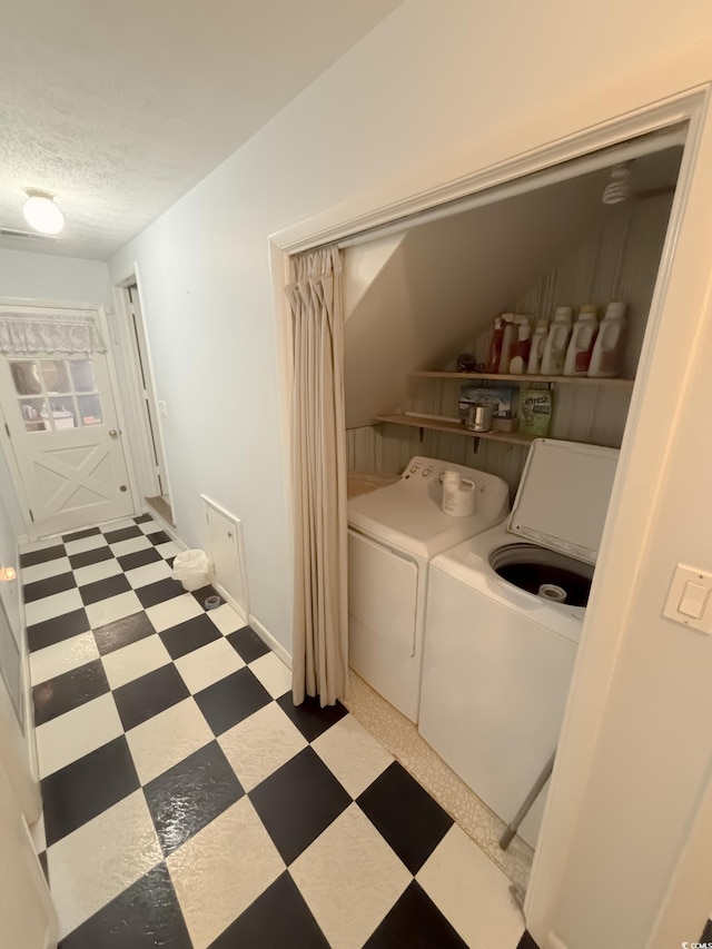 laundry area featuring laundry area, a textured ceiling, light floors, and independent washer and dryer