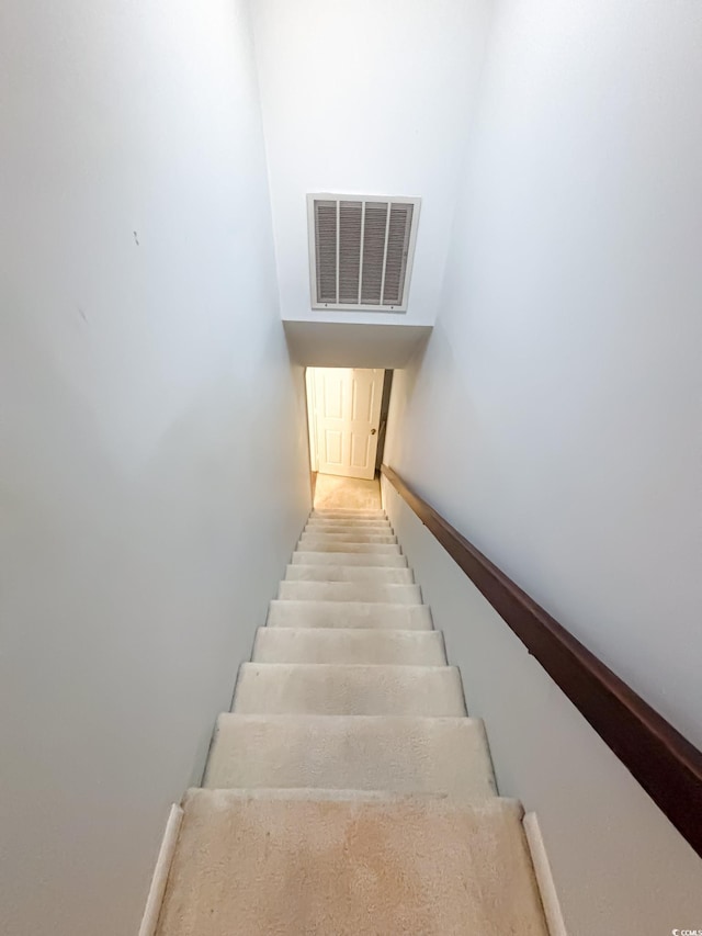 stairway with baseboards and visible vents