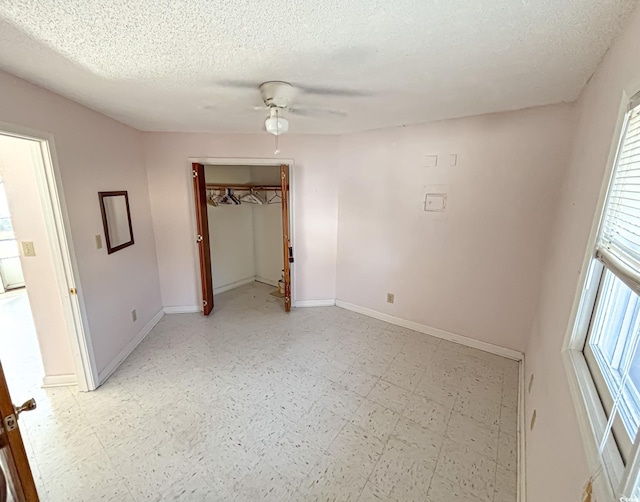 unfurnished bedroom with a textured ceiling, ceiling fan, baseboards, and light floors