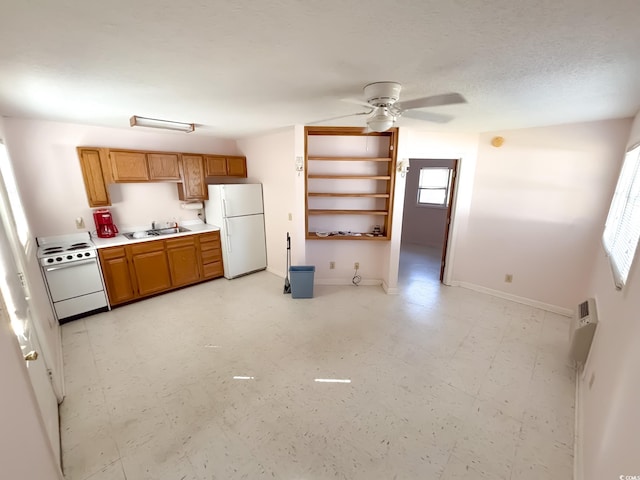 kitchen with a sink, a ceiling fan, white appliances, and a wealth of natural light