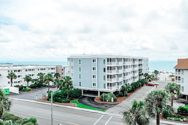 view of property featuring a water view and uncovered parking