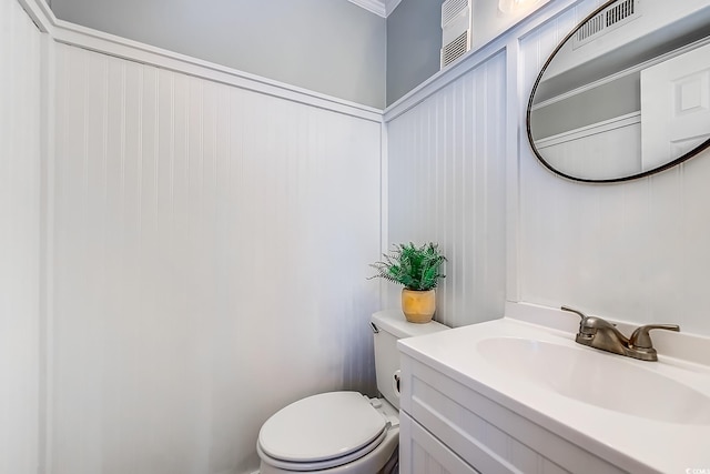 half bath featuring toilet, visible vents, and vanity