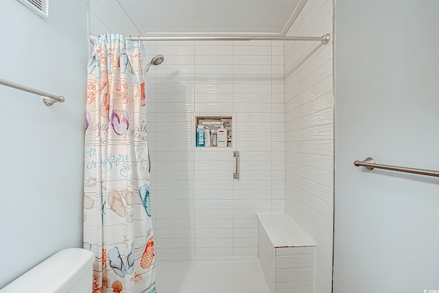 bathroom with visible vents, a shower stall, and toilet