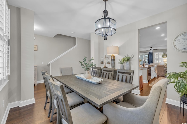 dining room featuring a notable chandelier, recessed lighting, dark wood finished floors, and baseboards