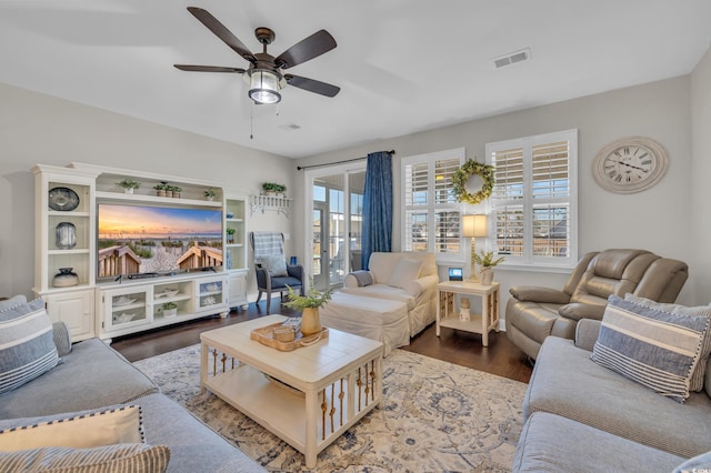 living area featuring ceiling fan, plenty of natural light, wood finished floors, and visible vents