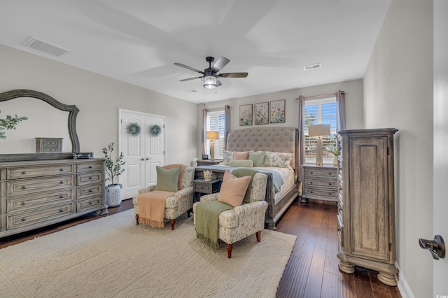 bedroom featuring dark wood-style floors, baseboards, visible vents, and a ceiling fan