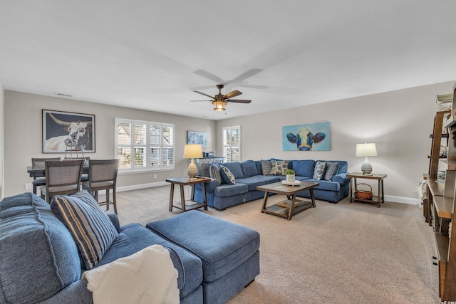 living room featuring light carpet, ceiling fan, and baseboards