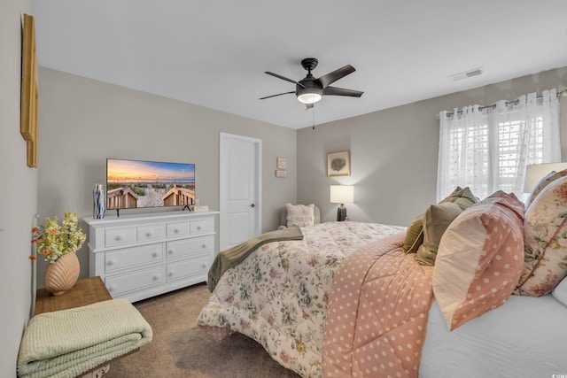 bedroom featuring ceiling fan, visible vents, and light colored carpet