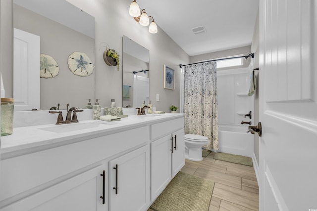 bathroom featuring toilet, shower / tub combo, a sink, visible vents, and double vanity