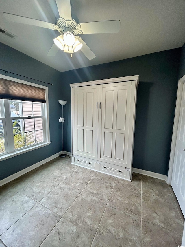 unfurnished bedroom featuring ceiling fan and light tile patterned floors