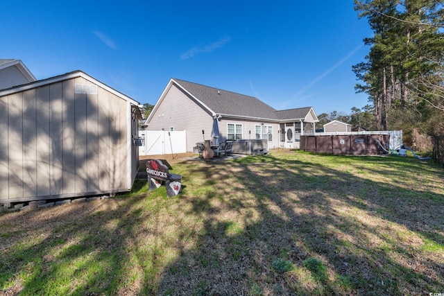 back of house with a fenced in pool and a yard