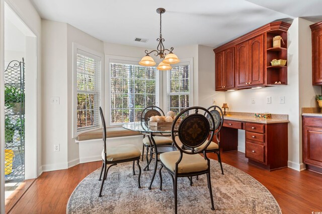 dining room with hardwood / wood-style flooring and an inviting chandelier