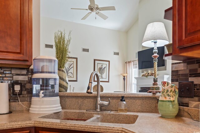 kitchen featuring ceiling fan, lofted ceiling, backsplash, and sink