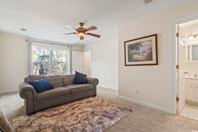 living room with ceiling fan, light colored carpet, and sink