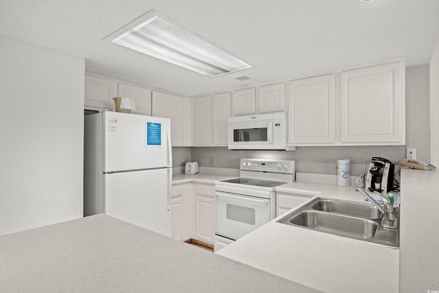 kitchen with white appliances, white cabinetry, and sink