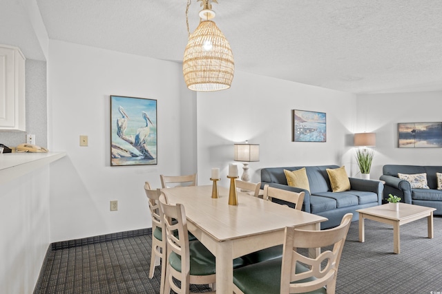 dining room with a textured ceiling and dark colored carpet