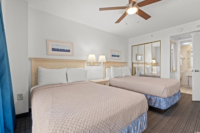 bedroom with ceiling fan, ensuite bathroom, a closet, and a textured ceiling