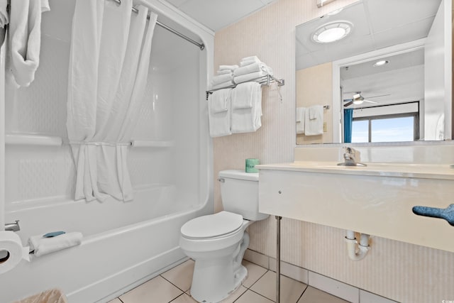 bathroom with ceiling fan, tile patterned flooring, shower / tub combo with curtain, and toilet