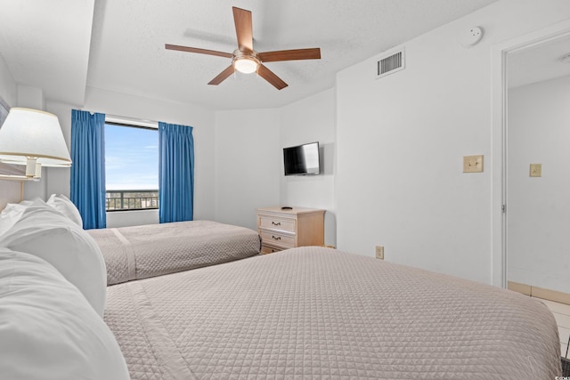 bedroom with ceiling fan and a textured ceiling