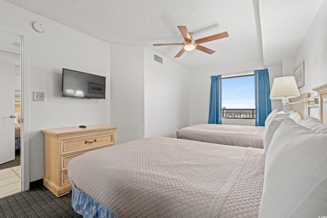 bedroom featuring ceiling fan and a textured ceiling