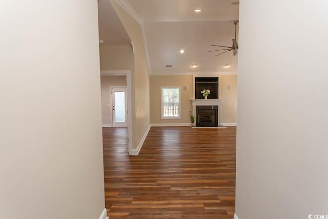 unfurnished living room featuring ornamental molding, dark wood-type flooring, and ceiling fan