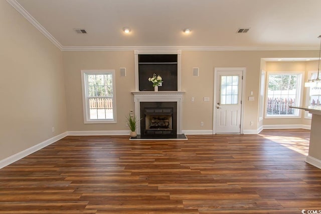 unfurnished living room with dark hardwood / wood-style flooring, a chandelier, and crown molding