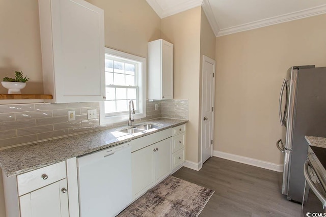 kitchen featuring sink, white cabinets, light stone counters, white dishwasher, and stainless steel fridge