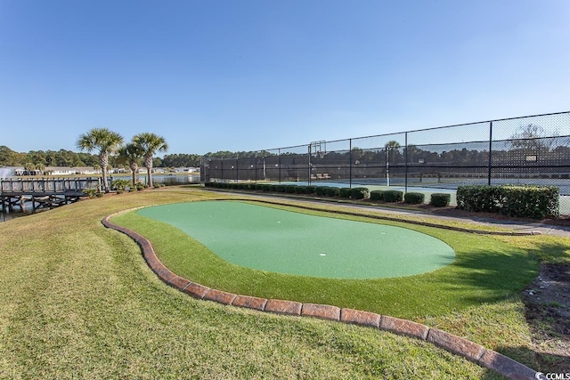 view of community with tennis court and a yard