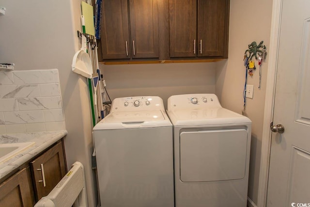 laundry room with independent washer and dryer and cabinets