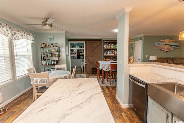 kitchen with dishwasher, a barn door, crown molding, and dark hardwood / wood-style floors