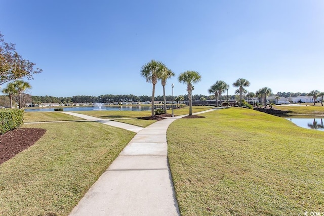 view of community featuring a water view and a lawn