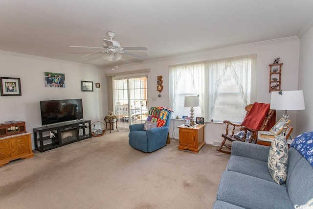 carpeted living room with ceiling fan and ornamental molding