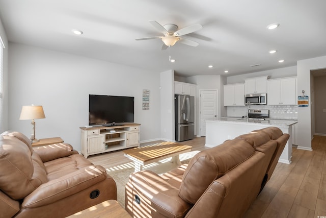 living room featuring ceiling fan and light hardwood / wood-style flooring